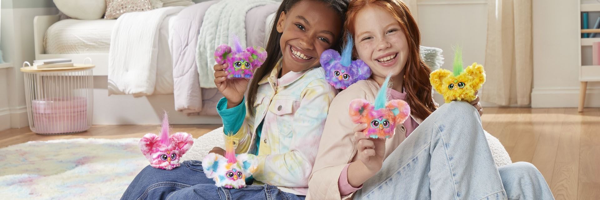 Two kids on a sofa with Furby toys